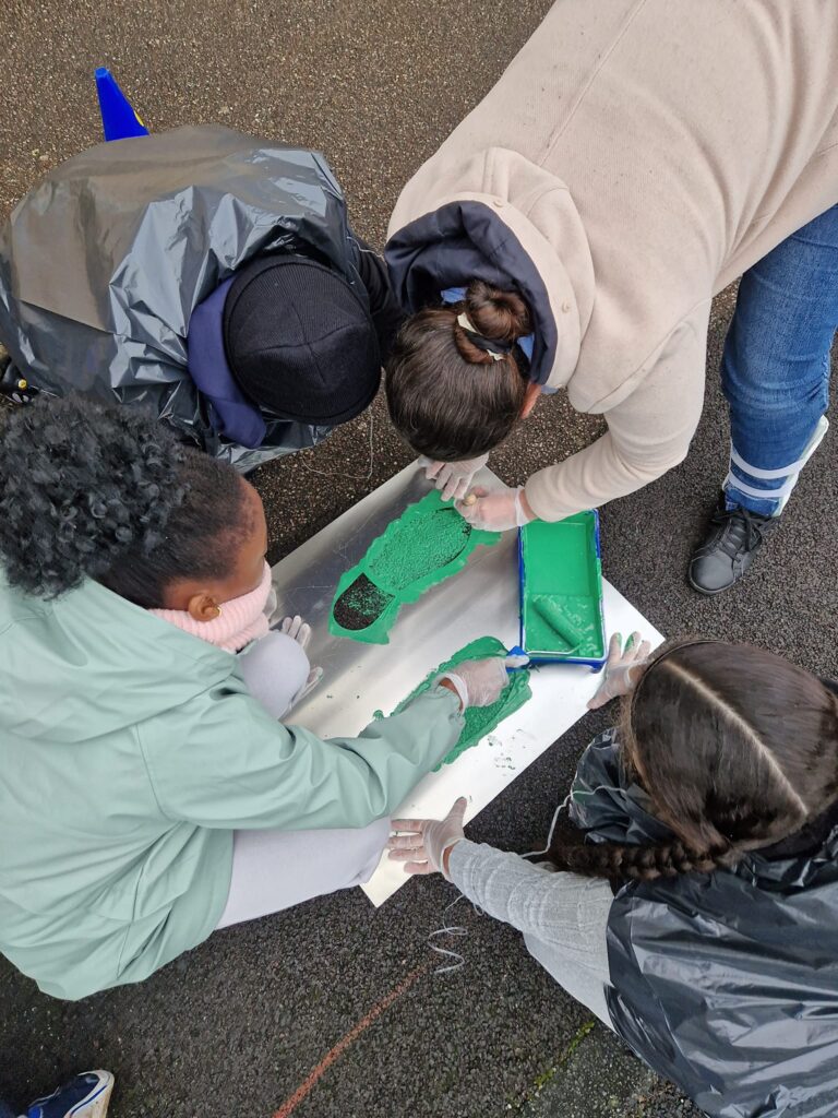 Enfants peignant des traces de pas vert